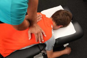Person rolling onto their side and using their arms to rise from bed with careful posture.